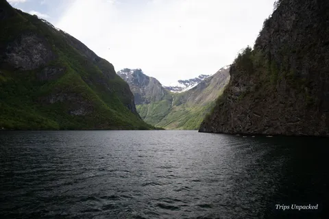 The narrow Nærøyfjord between steep cliffs, kayaks on the water