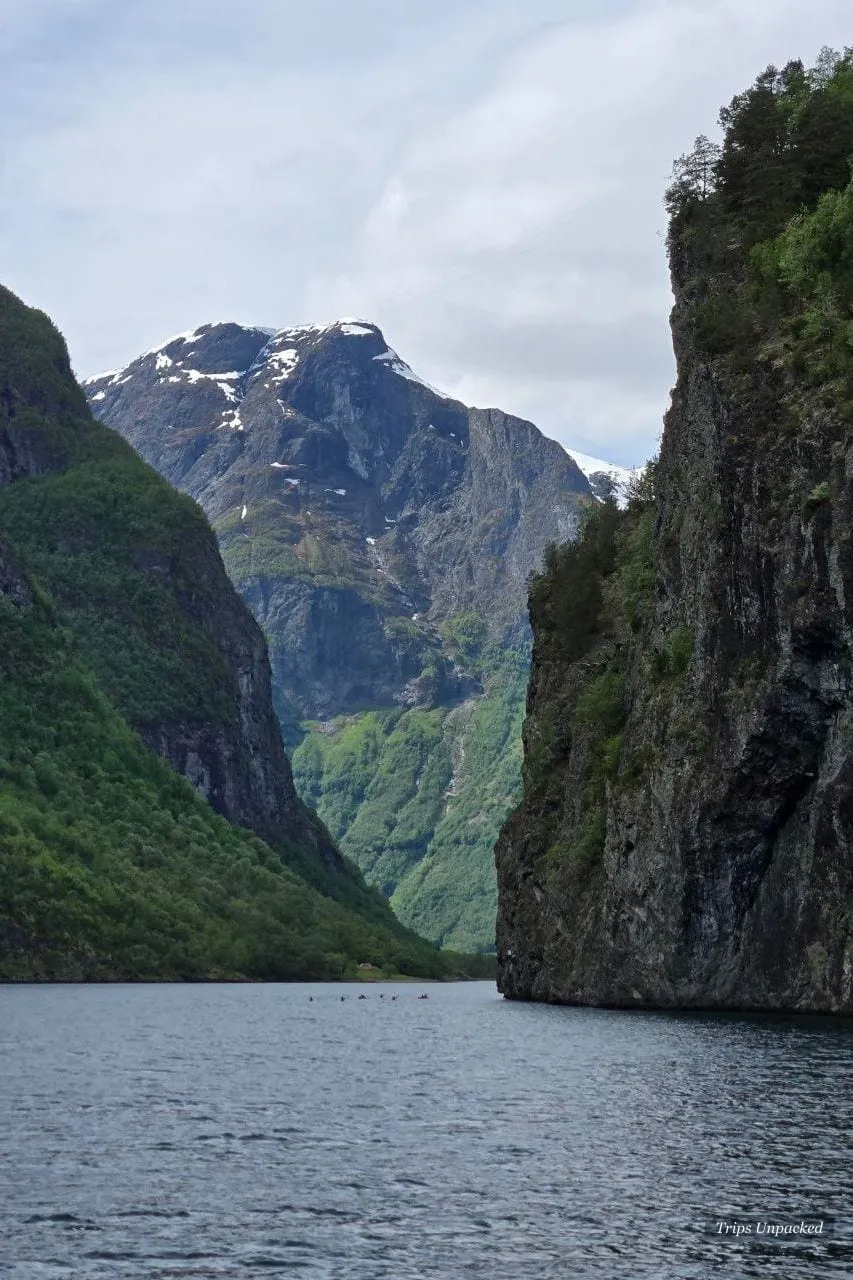 Kayakers dwarfed by the sheer rock walls of the narrow Nærøyfjord.
