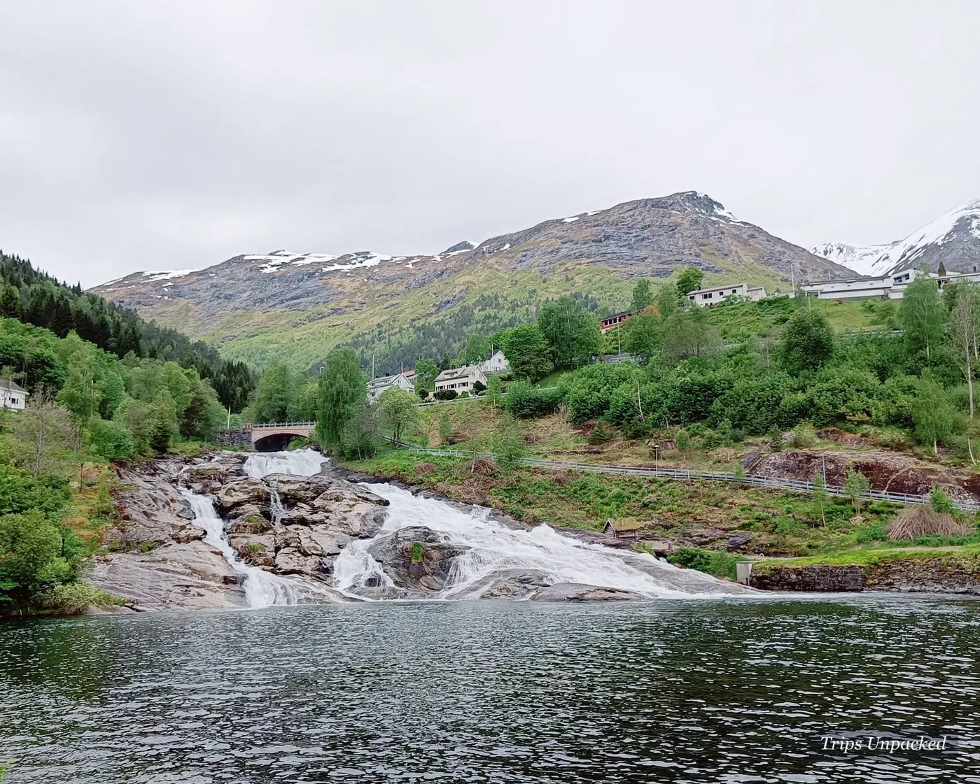 The Hellesylt waterfall tumbling under a road bridge into the fjord beside the village.