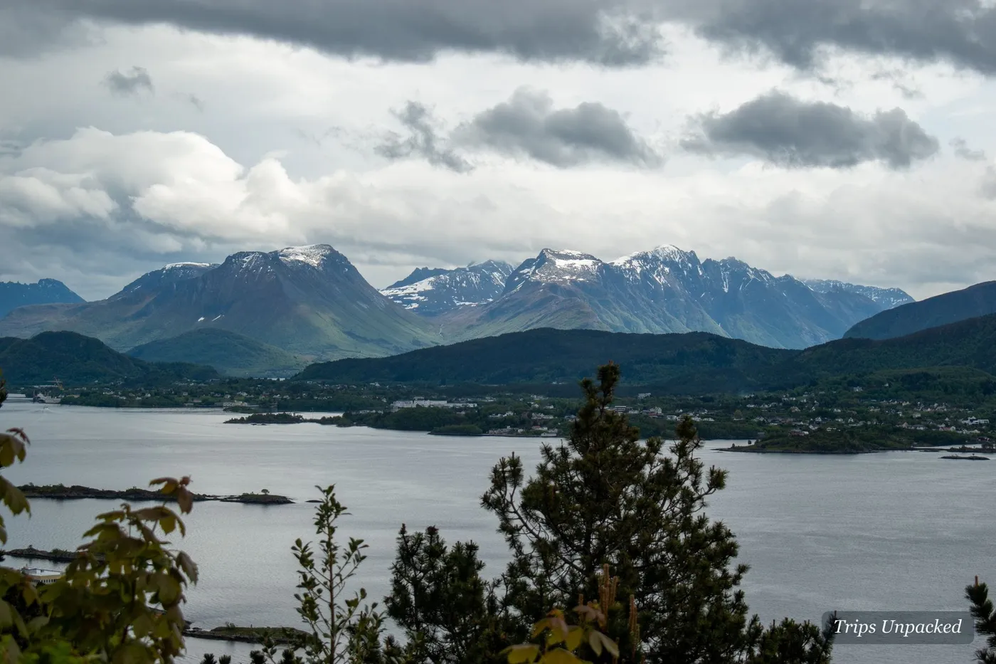 Snow-capped Sunnmøre peaks across the water from Ålesund, islands scattered in the fjord below.
